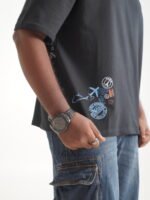 Dark oversized tee with travel stamps and Romanticising every wrong turn sleeve print Lascialo Essere Every Wrong Turn Drop 01